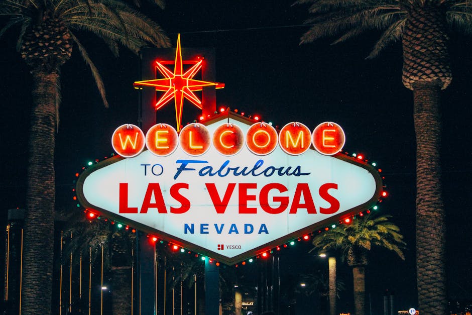 The iconic Welcome to Fabulous Las Vegas sign illuminated at night with palm trees in the background